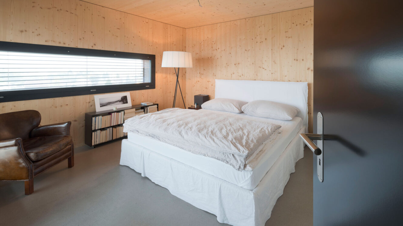 Schlafzimmer aus Holz mit grossem Fenster